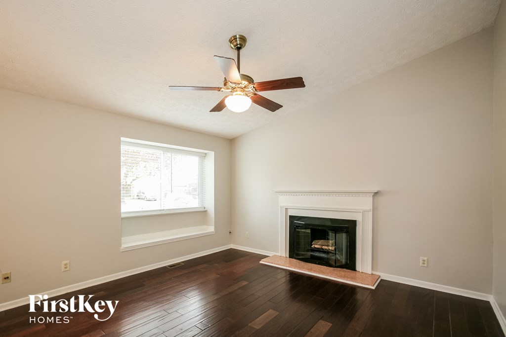 A room with a fireplace and a ceiling fan.