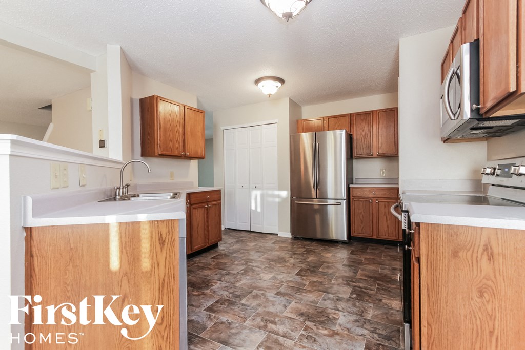 a kitchen with wooden cabinets and a stainless steel refrigerator