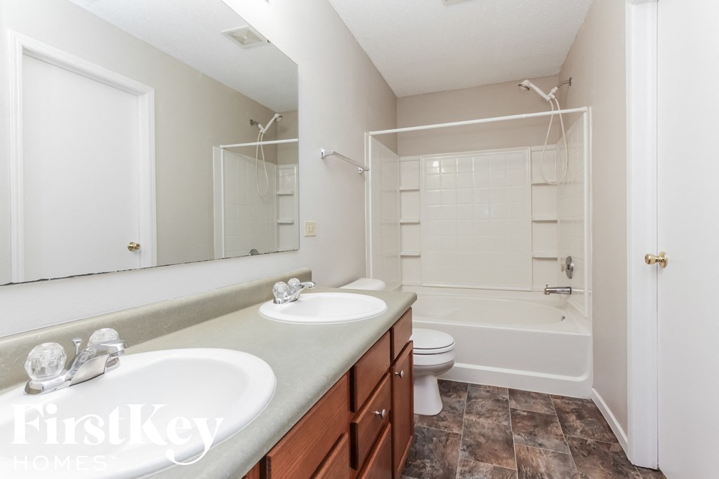 a bathroom with two sinks and a shower and a toilet