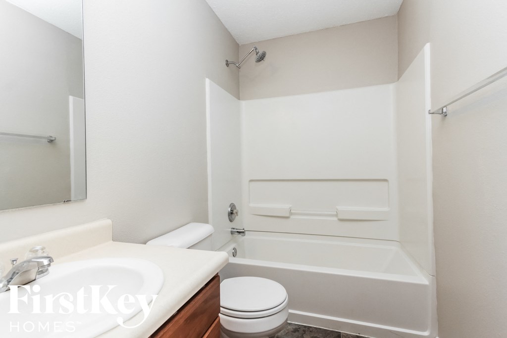 a white bathroom with a toilet and a tub and a sink