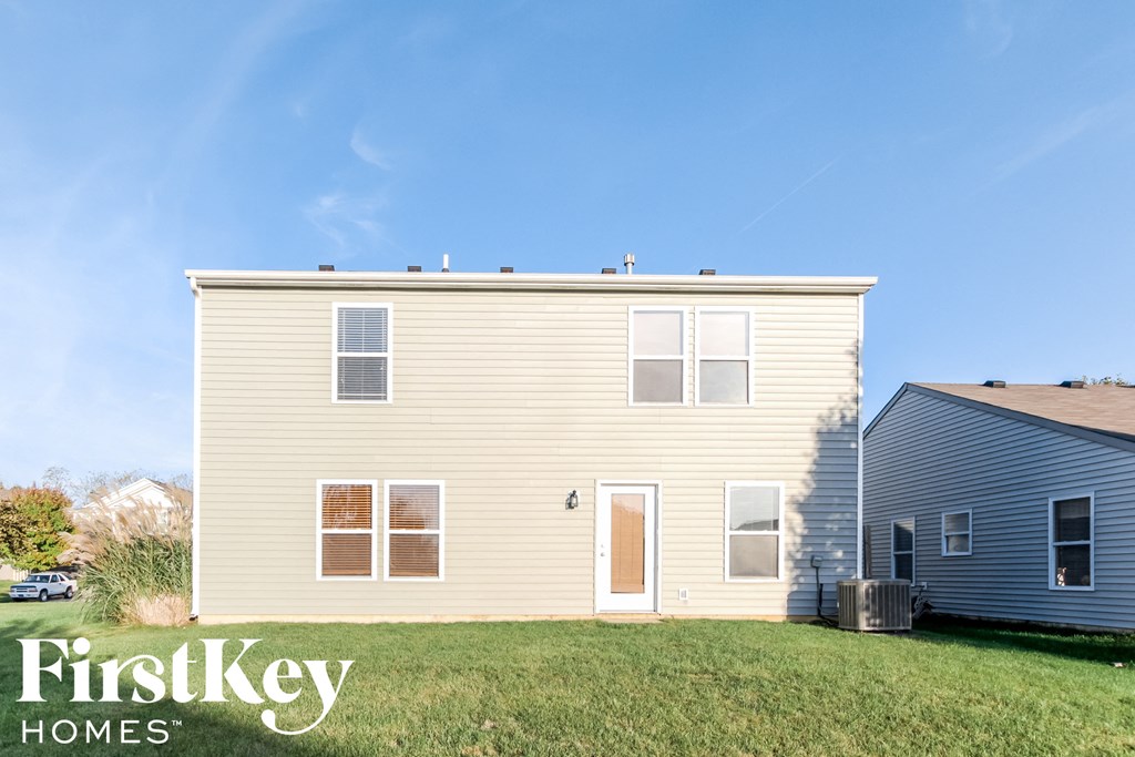 a yellow house with a yard in front of it