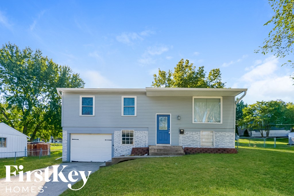 A house with a blue door and a white garage door.