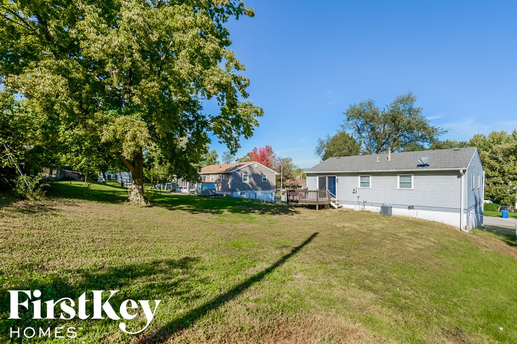 A house with a lawn and trees in front of it.