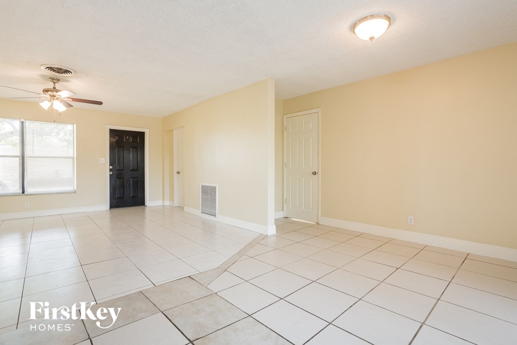 the living room and dining room are spacious and lighted by a ceiling fan