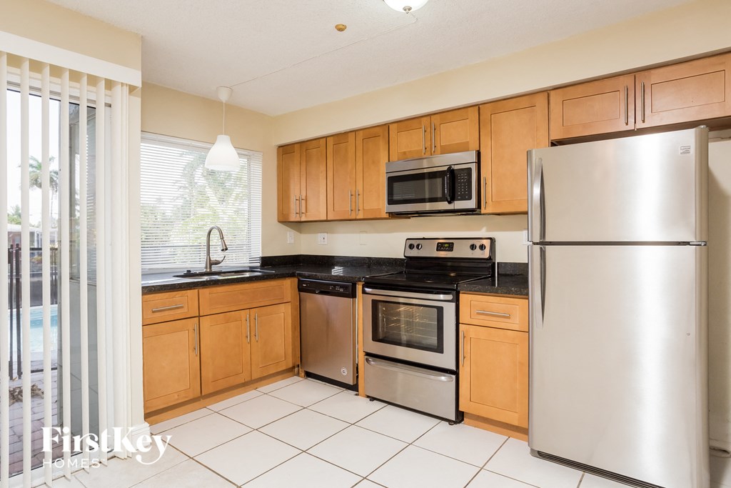 a kitchen with wooden cabinets and stainless steel appliances