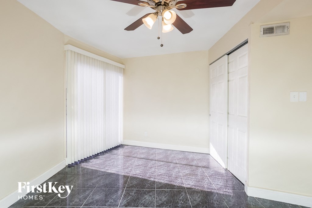 a living room with a ceiling fan and a closet