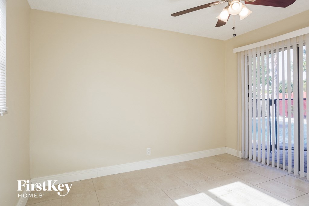 a living room with a sliding glass door and a ceiling fan
