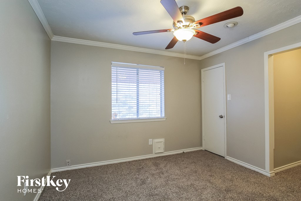 a bedroom with a ceiling fan and a window