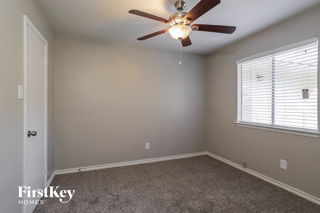 a bedroom with a ceiling fan and a window