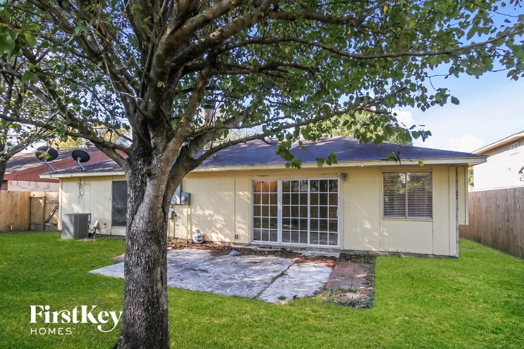 a small yellow house with a tree in the yard