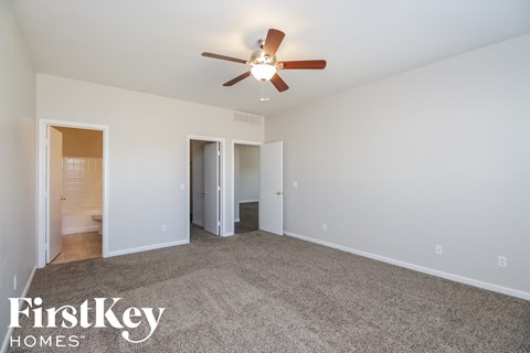 a living room with carpet and a ceiling fan