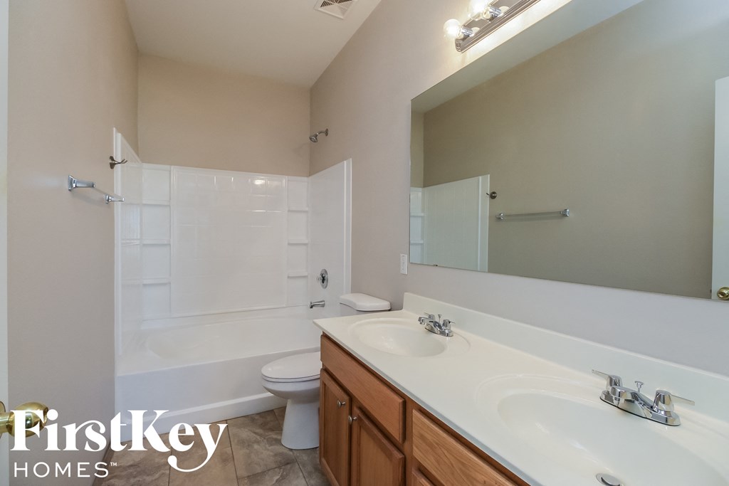 a bathroom with two sinks and a tub and a toilet