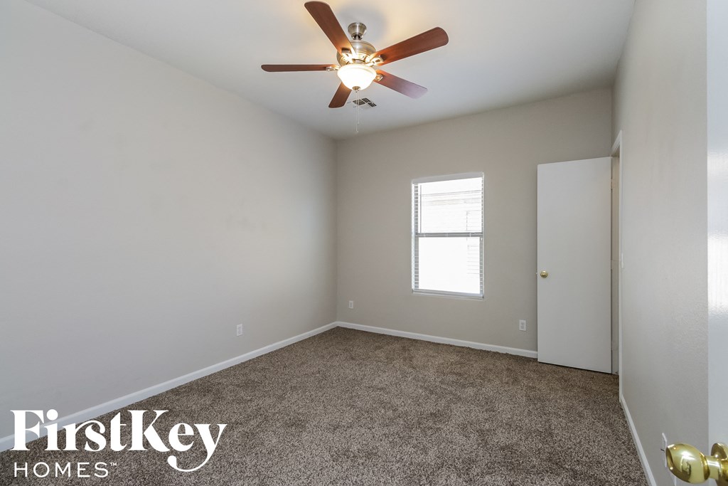 a empty room with a ceiling fan and a window