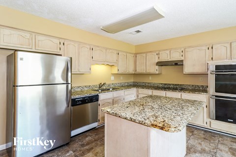 a kitchen with white cabinets and granite counter tops and stainless steel appliances