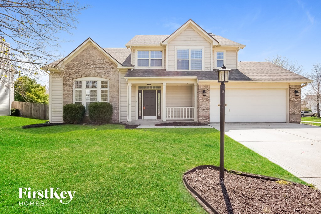 A house with a well-manicured lawn and a FirstKey Homes logo.