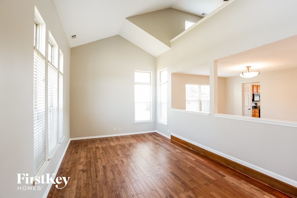 A spacious room with wooden floors and white walls.