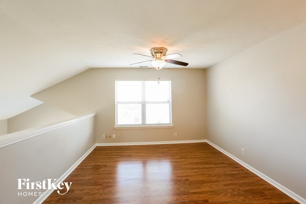 A room with wooden floors and a ceiling fan.