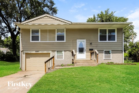 a tan and with a green lawn and trees