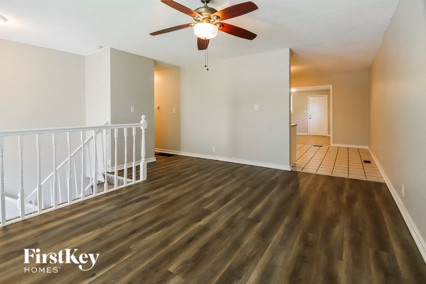 a living room with a staircase and a ceiling fan
