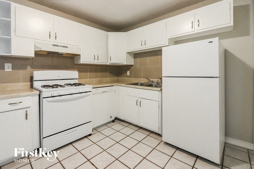 a white kitchen with white appliances and white cabinets