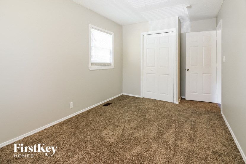 a bedroom with a carpeted floor and a white door