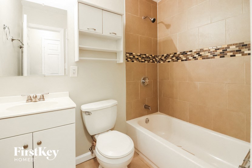 a bathroom with a toilet and a tub and a sink