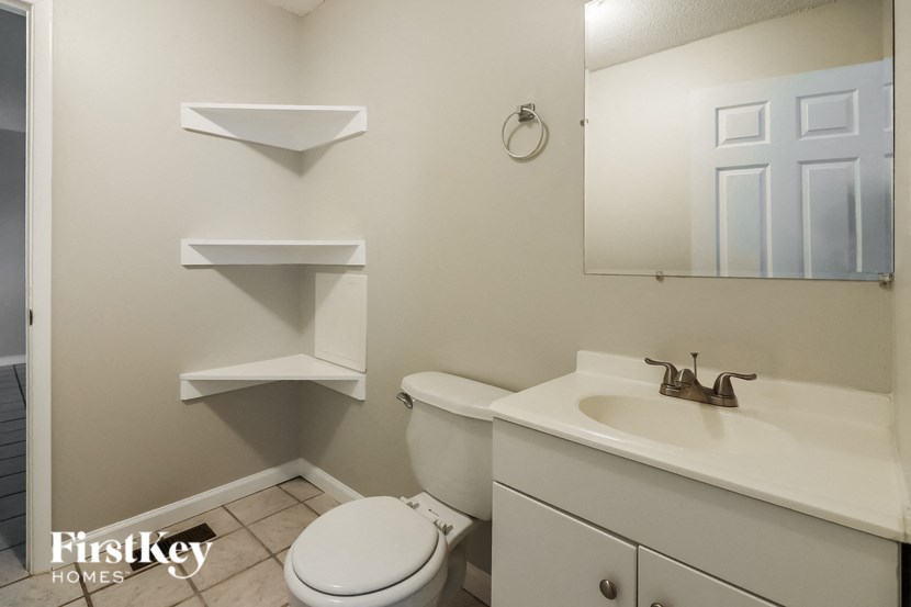a bathroom with a sink toilet and a mirror