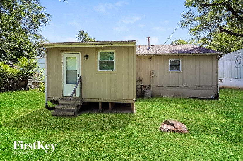 the exterior of a mobile home in a yard with a backdoor