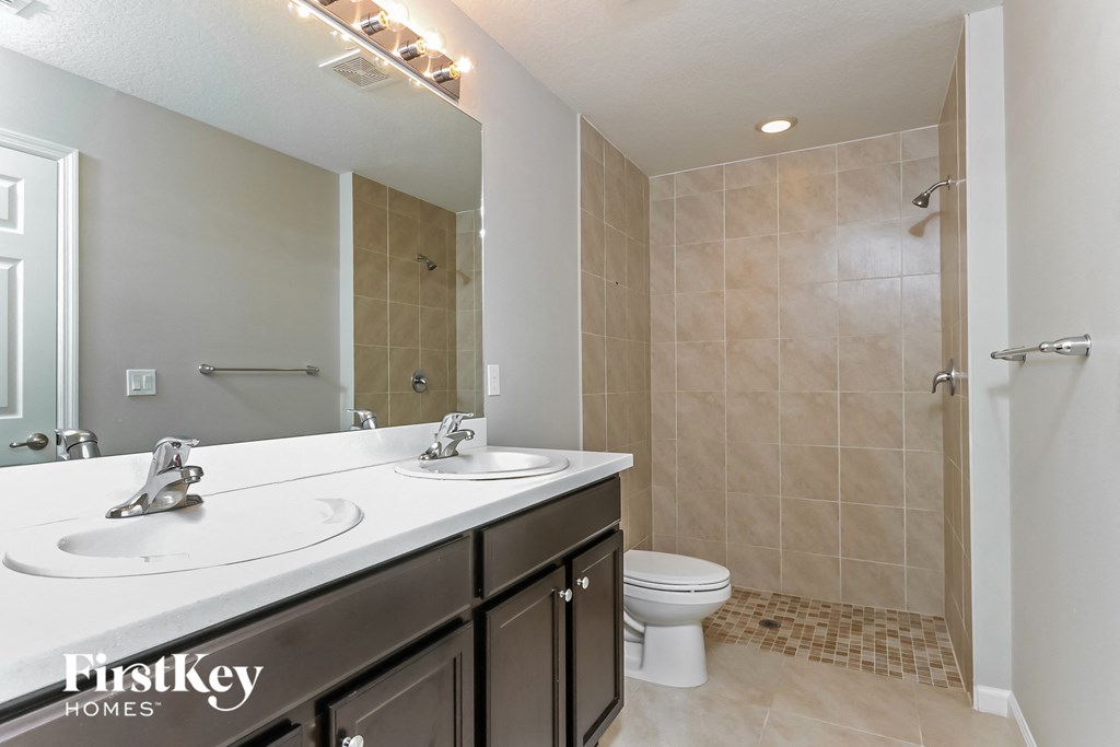 a bathroom with a toilet and a sink and a shower