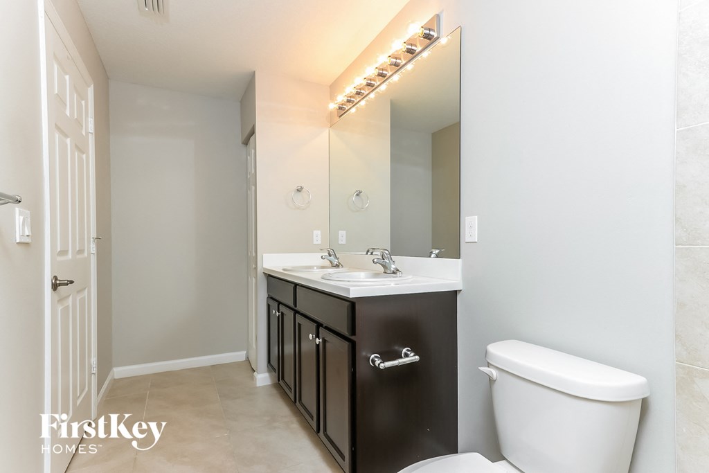 a bathroom with a toilet and a sink and a mirror
