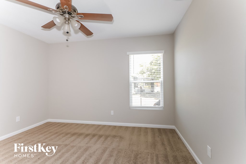 a living room with a ceiling fan and a window