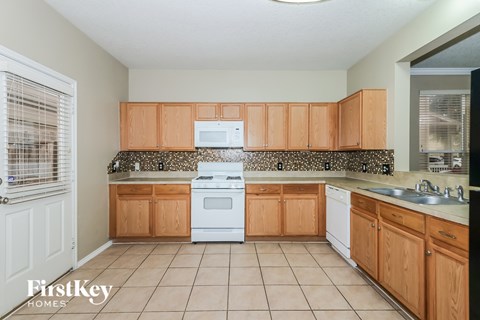 A kitchen with wooden cabinets and a white oven.