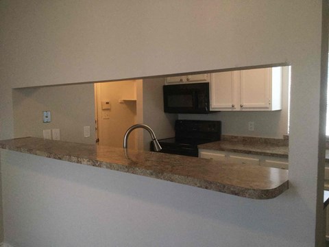 A kitchen with a microwave and oven built into the cabinetry.