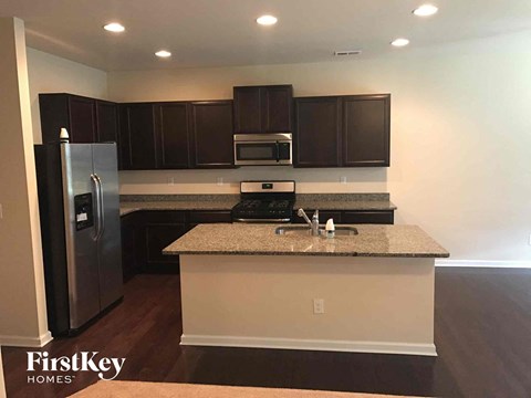 A kitchen with a granite countertop and a refrigerator.