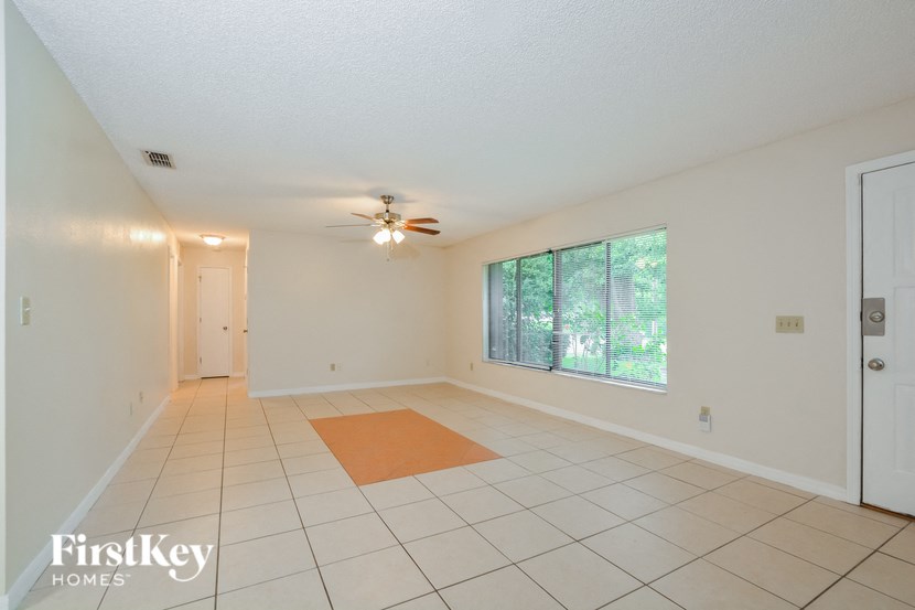 the living room and dining room are spacious and lighted by a ceiling fan