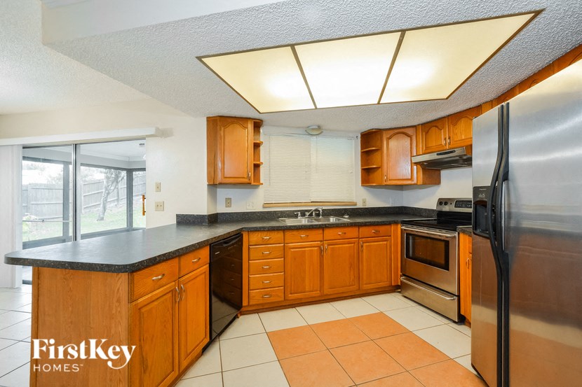 a kitchen with wooden cabinets and stainless steel appliances and a large window