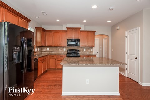 A kitchen with wooden cabinets and a granite countertop.