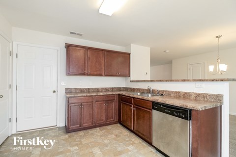 a kitchen with wooden cabinets and a stainless steel dishwasher