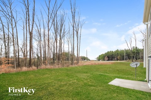 the backyard of a house with trees and grass
