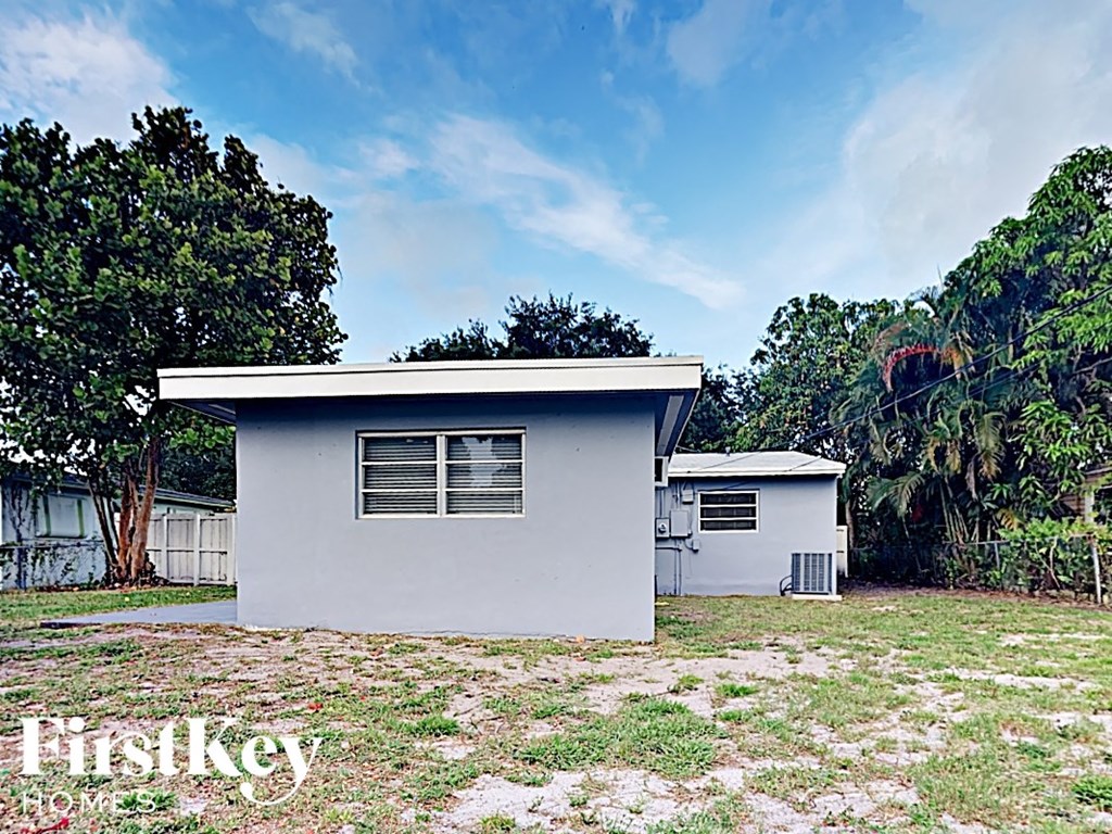 a small white house with a yard and trees