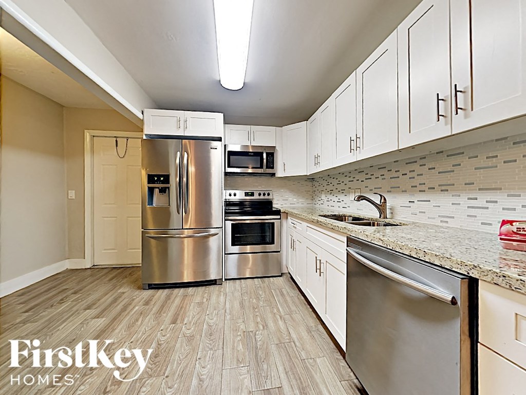 a kitchen with stainless steel appliances and white cabinets