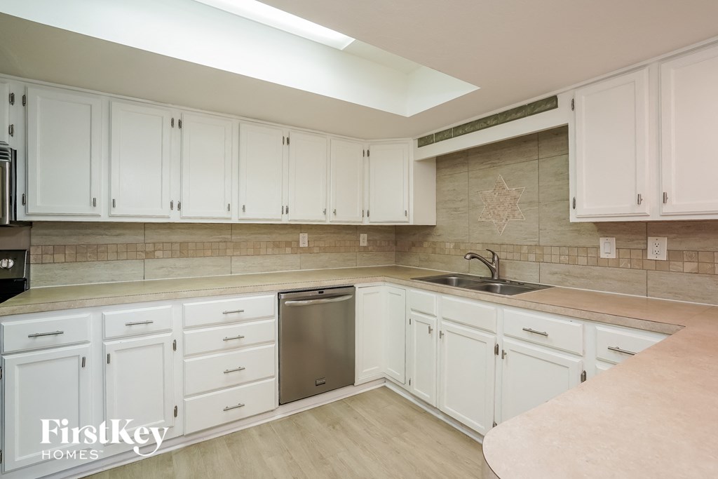 A kitchen with white cabinets and a star tile backsplash.