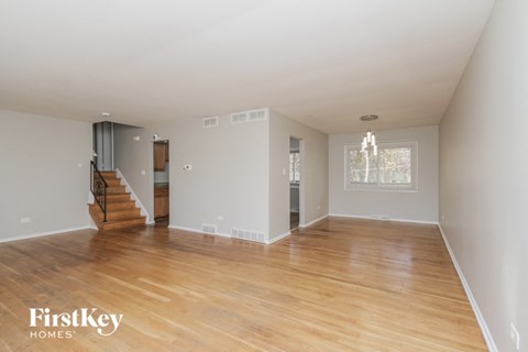 an empty living room with a hard wood floor and a staircase