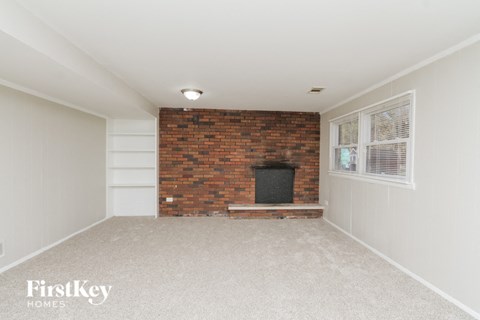 a living room with a brick fireplace and a window