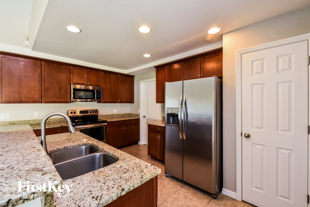 A kitchen with a granite countertop and stainless steel appliances.