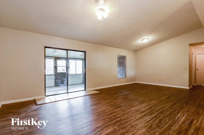 an empty living room with wood floors and a sliding glass door