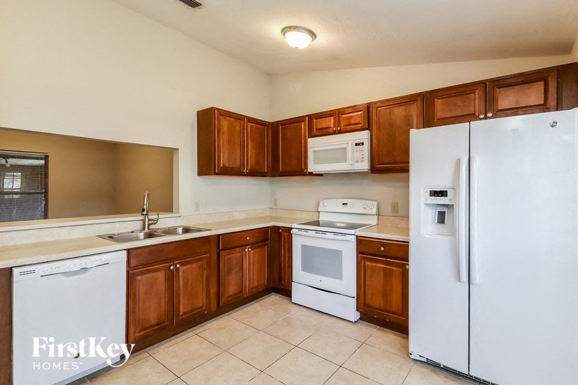 a kitchen with white appliances and wooden cabinets