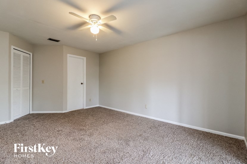 a empty room with a ceiling fan and a closet