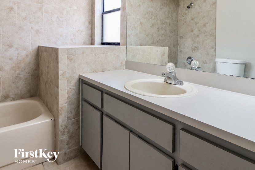 a bathroom with a sink and a tub and a mirror