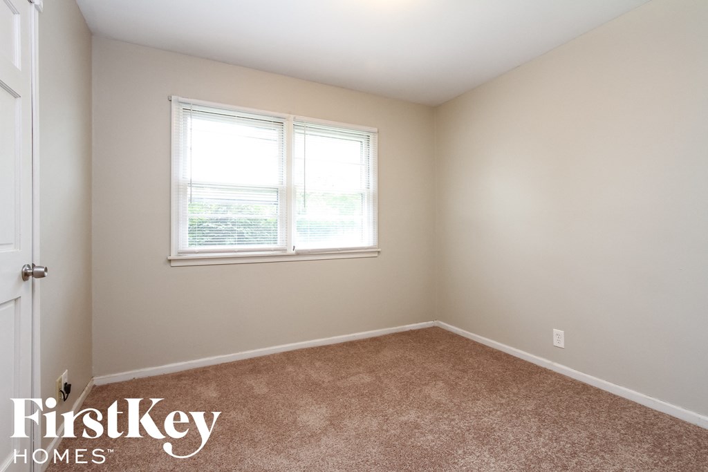 a bedroom with a carpeted floor and two windows